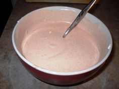 a bowl filled with pink liquid on top of a counter