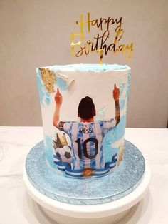 a blue and white birthday cake with an image of a soccer player on it