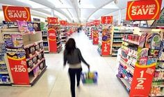 a woman is walking down the aisle of a store with shopping bags in her hand