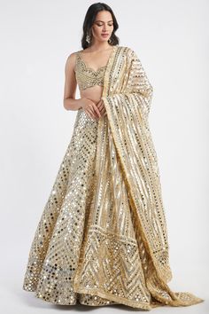 Featuring a gold lehenga in net base with mirror, gota and zari hand embroidery. It is paired with a matching blouse and a dupatta.     FIT: Fitted at bust and waist.  COMPOSITION: Net.  CARE: Dry clean only. Abhinav Mishra Lehenga, Nikkah Aesthetic, Embellished Lehenga, Abhinav Mishra, Golden Lehenga, Gold Lehenga, Wedding Wardrobe, Golden Mirror, Reception Lehenga