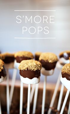 chocolate covered marshmallows are sitting on top of white sticks with the words s'more pops above them