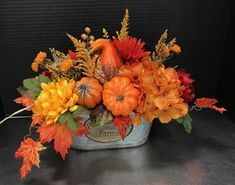 a basket filled with lots of different types of flowers and leaves on top of a table