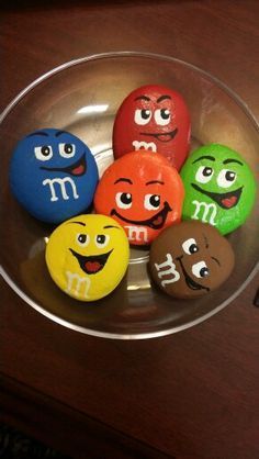 six colorful rocks with different faces in a bowl