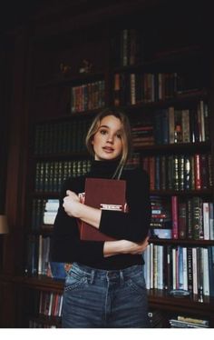 a woman standing in front of a bookshelf with her arms crossed