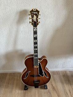 an acoustic guitar sitting on top of a wooden floor