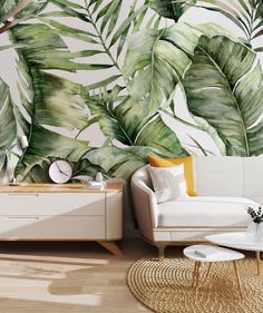 a living room scene with a couch, coffee table and wall mural featuring tropical leaves