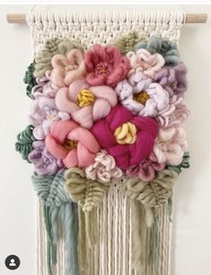 the wall hanging is decorated with flowers and tassels on it's sides