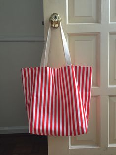 "This item is finished and ready to ship! Your order will go out in 1-2 business days. This versatile tote is limited edition and one of a kind! Made with durable red striped canvas on the outside with waterproof PUL fabric on the inside. Perfect for a beach or pool tote, or to carry your books, baby accessories, or farmer's market fare. Meausrements 16\" across the top 11.5\" across the bottom 13\" tall 6\" deep 22\" straps (11\" drop) Please review my shop policies for more information: http:/ Fabric Lantern, Pul Fabric, Tshirt Blanket, Market Tote Bag, Pad Bag, Small Cosmetic Bags, Pdf Quilt Pattern, Memory Quilt, Pink Moon