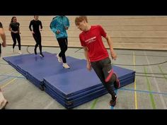 a group of people standing on top of a blue mat