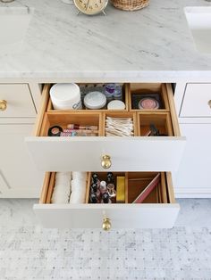 an open drawer in a kitchen next to a counter top with candles and other items