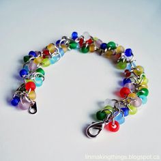 a multicolored beaded bracelet on a white surface with a metal hook clasp