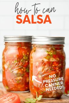 two mason jars filled with canned salsa on top of a wooden cutting board next to tomatoes