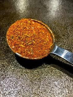 a pan filled with seasoning sitting on top of a counter next to a spatula