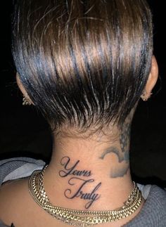 the back of a woman's neck with her name tattooed on it