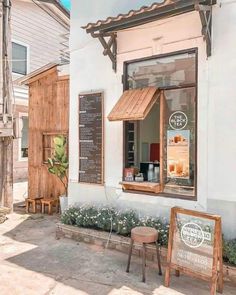 an outside view of a small restaurant with wooden tables and chairs in front of it