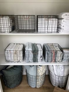 baskets and blankets are stacked on shelves in the closet