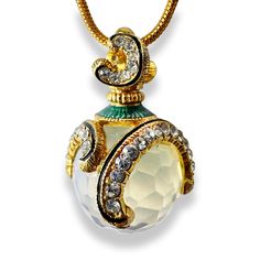 This high-quality, handmade, magnificent pendant was inspired by and designed in a Faberge style. The 14mm faceted imitation moonstone crystal ball is set in a 24k gold-plated 925 sterling silver, elegant, asymmetric, curvy design with chains of 1.5mm shining clear Premium Crystals The bail, on top, is finished with crystals on both sides. Transparent Guilloché bright blue enamel also gives the item a beautiful effect. The pendant is approximately 1.1 inches in height and comes with a gold-plated 24-inch snake chain that is set together in a jewelry box.  I am a professional jewelry designer, who graduated from Saint Petersburg's Art and Design Academy. Immigrating to the USA, I brought back Faberge's style and traditional art with a twist. The egg is a universal symbol of New Life, Luck, Spiritual Round Pendant Necklace With Stone Setting, Jeweled Pendant Necklaces For Gifts, Collectible White Locket Jewelry, White Amulet Style Collectible Jewelry, Moonstone Crystal, Professional Jewelry, Birthstone Gifts, Snake Chain, Sterling Silver Necklaces