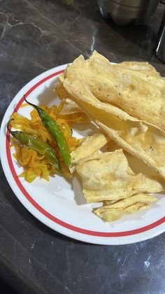 there is a plate with chips and peppers on the table next to some sauces