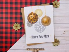 a close up of a greeting card on a wooden surface with christmas decorations and snowflakes