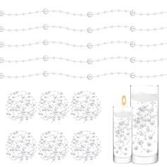 two candles are next to some beads and chains on a white background, one candle is lit in the middle