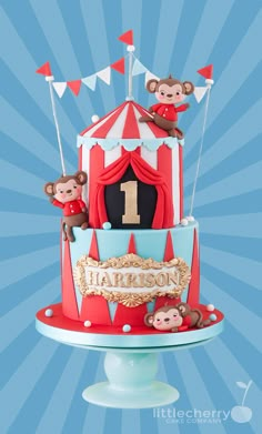 a birthday cake with monkeys on top and a circus tent for the first number one