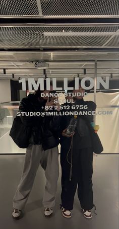 two women standing next to each other in front of a glass sign that says million