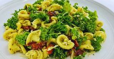 a white plate topped with pasta and broccoli