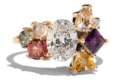 an image of a ring with different colored stones on the sides and gold tone setting