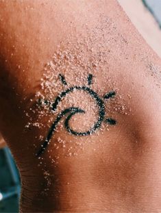 the back of a person's shoulder with white sand on it