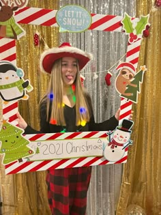 a woman holding up a sign with christmas decorations on it