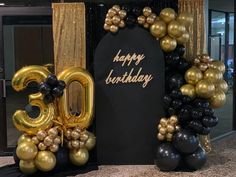 a black and gold 30th birthday decoration with balloons