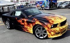 a car with flames painted on it parked in a parking lot