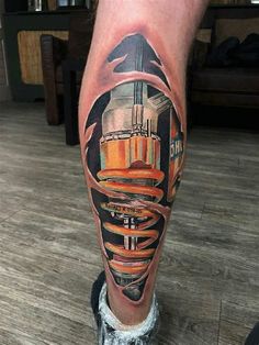 a man's leg with a colorful tattoo on it and an image of a building