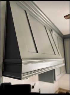 an image of a kitchen with white cabinets and black trim on the bottom half of the range hood