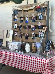 a table topped with pictures and candles on top of a checkered cloth covered table