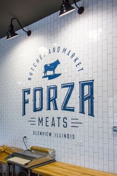 a sign for a restaurant that says frozen meats on the wall and below it is a wooden table with utensils