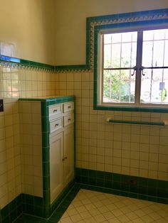 an empty bathroom with green and white tile