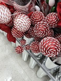 red and white lollipops sitting on top of each other in a container