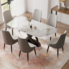 a dining room table with chairs and a rug on the floor in front of it