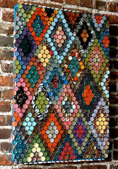 an art piece made out of bottle caps on a brick wall