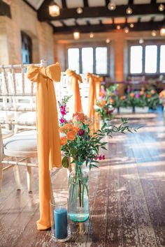 an aisle with chairs and flowers in vases on the floor next to each other