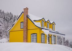 a yellow house with snow on the ground