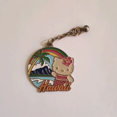 a hello kitty keychain with the word hawaii on it's front and back