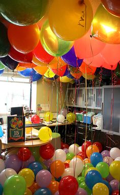 a room filled with lots of balloons floating in the air