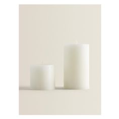 two white candles sitting next to each other