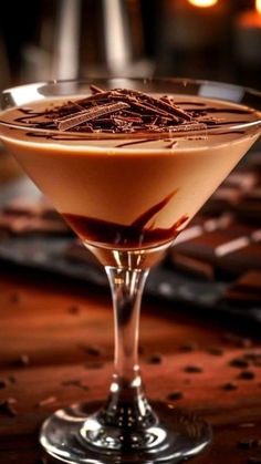 a glass filled with liquid sitting on top of a wooden table