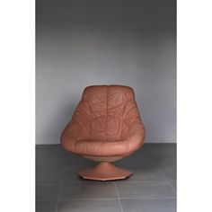 a brown leather chair sitting on top of a tile floor