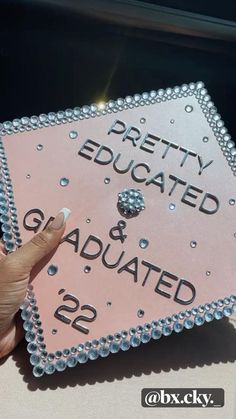 a pink and silver graduation cap with the words pretty educated and graduated 22 on it