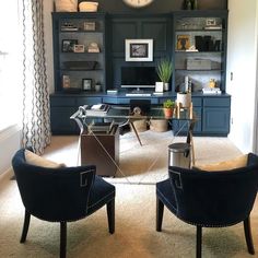 two chairs in front of a desk with a clock on the wall above it and other office furniture