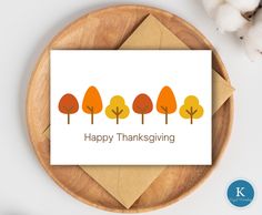 a card with the words happy thanksgiving written in orange and yellow trees on it next to cotton